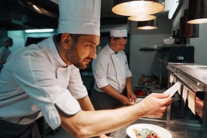 Chef viendo los pedidos que están por entregar Chef viendo los pedidos que están por entregar